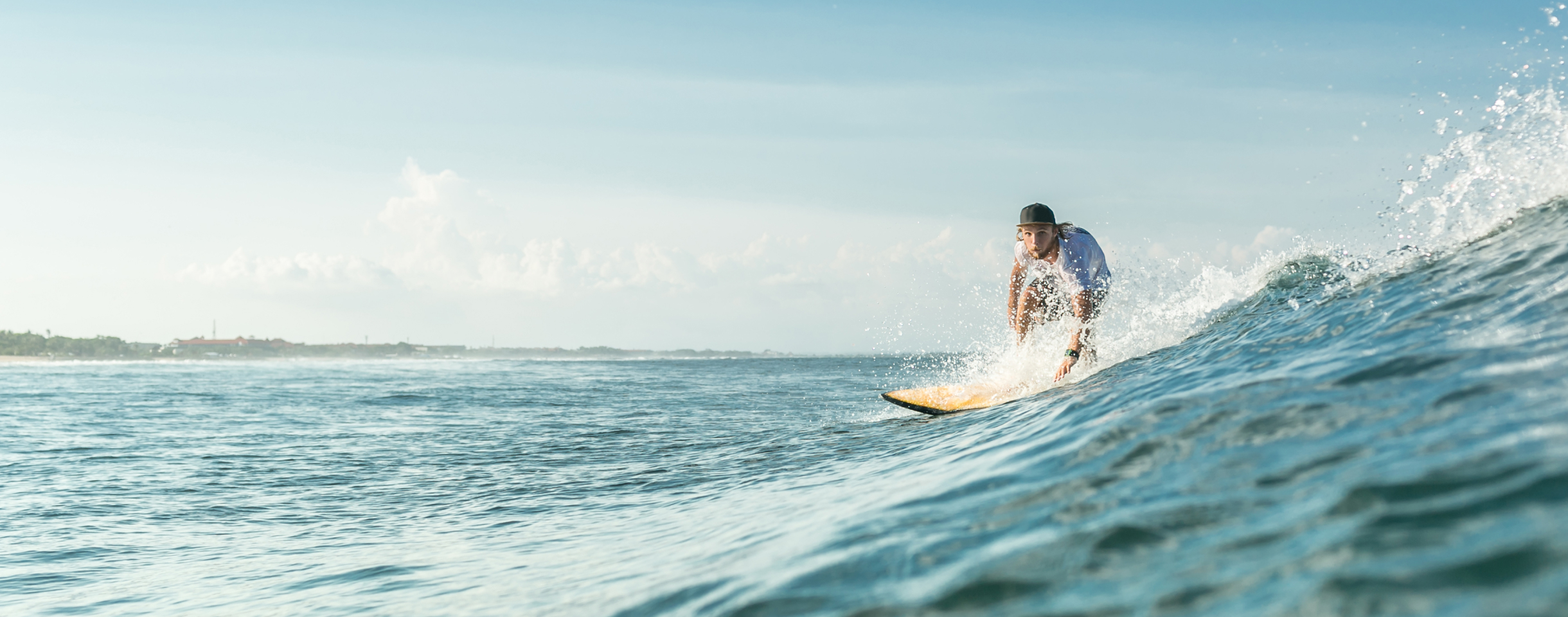 Surfer riding a wave at sunset